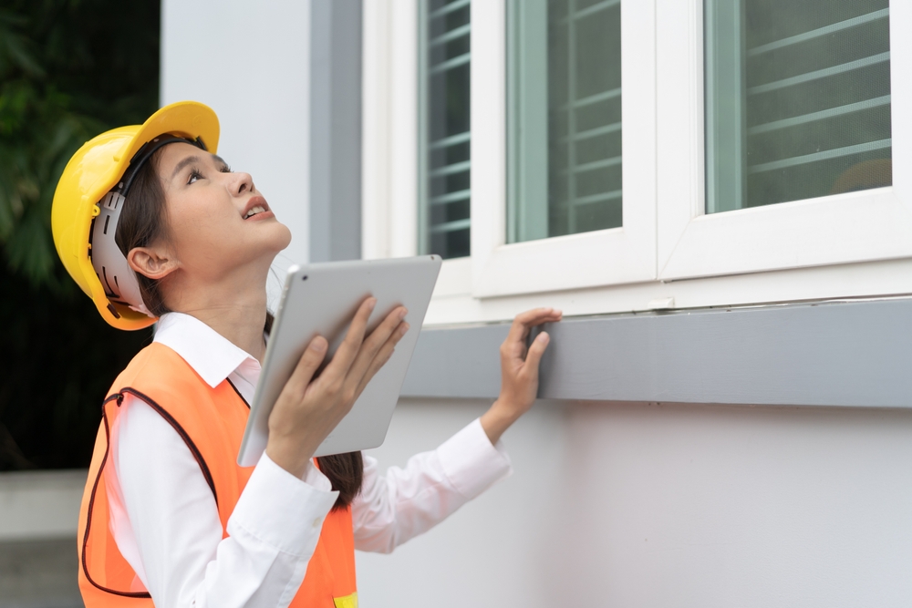 หญิงสาวกำลังตรวจบ้านบริเวณประตู หน้าต่าง หรือช่องเปิดต่าง ๆ