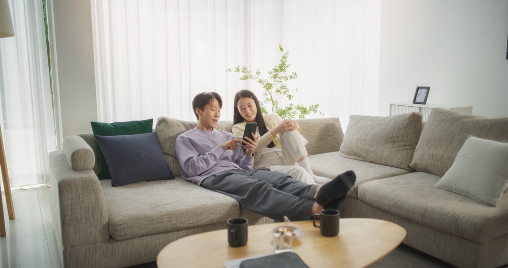 14_buy-house-vs-condo.jpg คู่รักกำลังมองสมาร์ตโฟนก่อนตัดสินใจซื้อที่อยู่อาศัยไว้ลงทุน