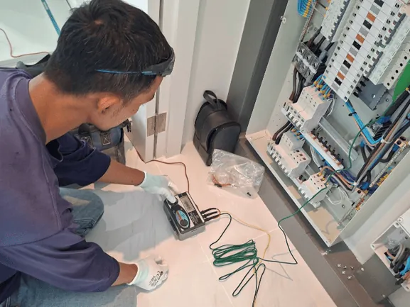 ช่างของเอพีใช้เครื่องตรวจสอบเต้ารับไฟฟ้า (Socket Tester) เช็กระบบไฟและสายดินเพื่อความปลอดภัยก่อนปิดทับผนัง