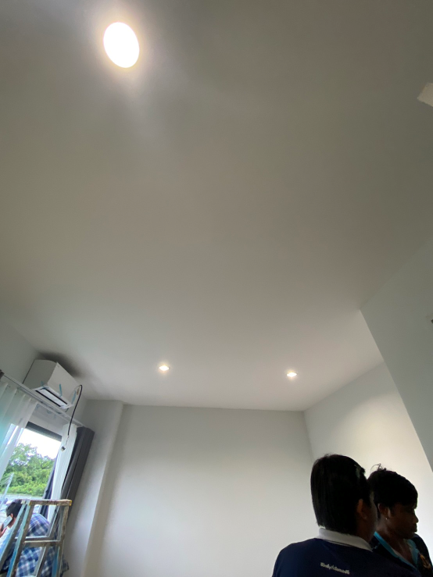 ฝ้าเพดานภายในบ้านที่มีการติดตั้งหลอดไฟดาวน์ไลต์และเปิดทดสอบแสงสว่าง