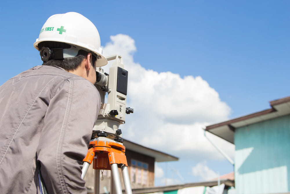 04_what-is-building-setback-regulations.jpg วิศวกรกำลังวัดระยะร่นด้านข้างและด้านหลัง