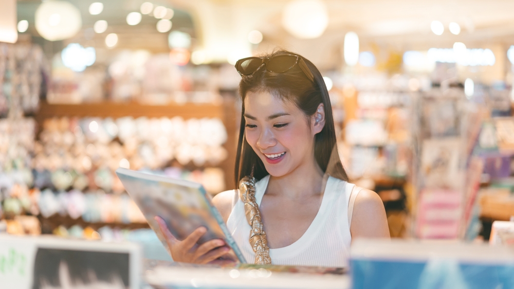 หญิงสาวกำลังยืนเลือกซื้อหนังสือในร้านบนห้างสรรพสินค้า