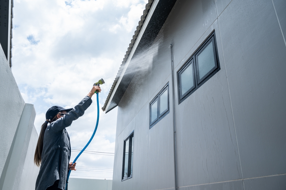 01_ap-fixes-water-leaks.jpg ช่างกำลังฉีดน้ำทดสอบ (Water Test) บริเวณหลังคาและผนังบ้านเพื่อตรวจสอบปัญหารั่วซึมตามมาตรฐาน AP
